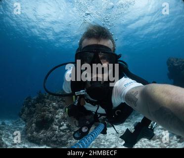 young dive instructor taking a selfie in the caribbean ocean Stock Photo