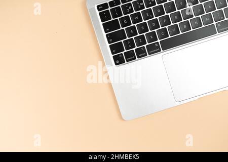 Modern laptop keyboard flat lay beige background. Office workplace table, minimal design concept. Top view, copy space Stock Photo