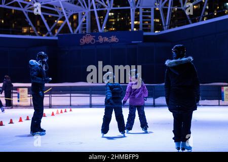 Toronto, Canada. 07th Feb, 2022. Kids take a skating lesson along a brightly-lit outdoor ice rink.The Nordic Lights outdoor winter exhibition, a display of Nordic and Canadian light art at the Toronto Harbourfront Centre, co-produced with Fjord Studio. (Photo by Katherine Cheng/SOPA Images/Sipa USA) Credit: Sipa USA/Alamy Live News Stock Photo