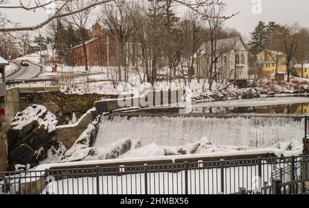 dam controlling the flow of icy water of the  Ottauquechee River in Quechee, Vermont Stock Photo