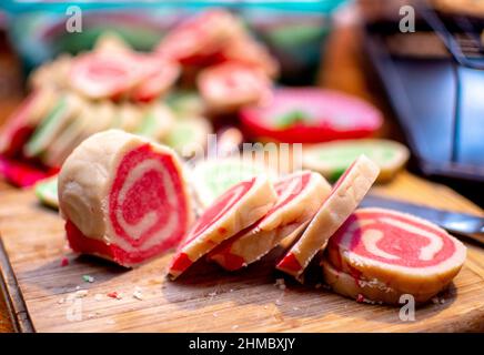 a log of dough is sliced into rounds to show off the spiral in these festive christmas cookies Stock Photo