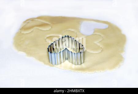 hearts stamped out of dough with this metal cookie cutter, will make delicious cookies Stock Photo