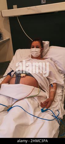 pregnant young woman dilating in delivery room, waiting to give birth at hospital Stock Photo