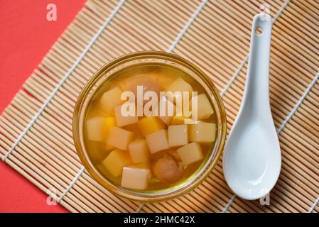 Chinese desserts, Mix ginkgo nuts cassava syrup coconut jelly in longan juice on glass bowl, Thai and Chinese longan date soup Asian dessert sweets Stock Photo