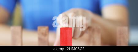 Female hand choosing red block among wooden closeup Stock Photo