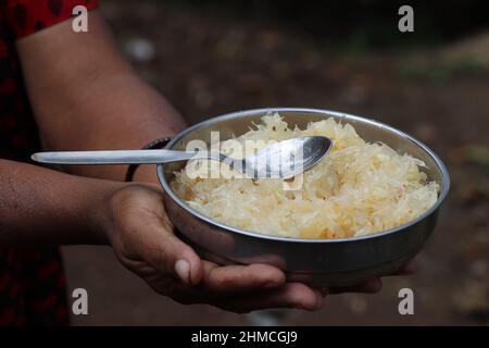 Peeled Grapefruit in a bowl with spoon ready to be served held in hand. Fresh Fresh peeled pomelo or pummelo Stock Photo