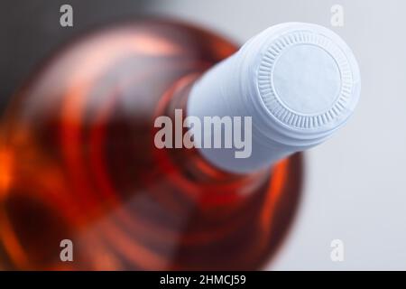 top view closeup of rose wine bottle mockup with light blue blank cap enclosure in focus Stock Photo