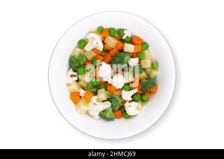 top view closeup of fresh mixed frozen vegetables with carrots peas broccoli and potatoes on round plate isolated on white background Stock Photo