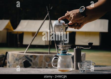 Drip coffee man pouring hot water on coffee ground with filter. Stock Photo