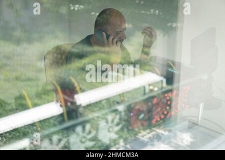 Young programmer adjusting cryptocurrency mining rig to optimal operational settings. High quality photo Stock Photo