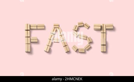 The word FAST made from cardboard boxes on a pink background. Stock Photo