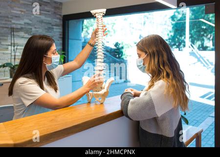Physiotherapist showing and pointing the spinal hernia to patient Stock Photo