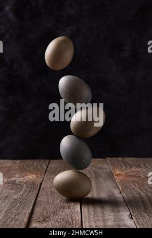 Balancing dyed eggs on wooden table. Easter celebration concept Stock Photo