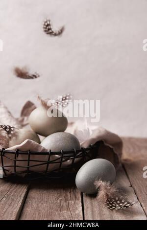 Eggs and feathers on rustic wooden table. Easter celebration concept Stock Photo