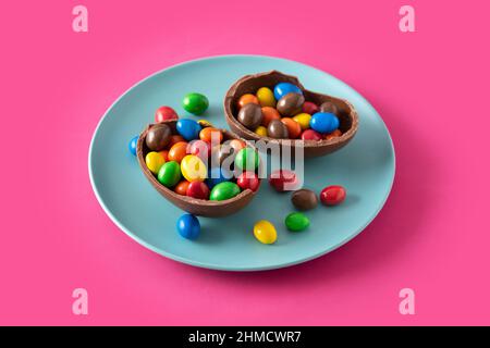 Colorful chocolate Easter eggs on pink background Stock Photo