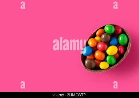 Colorful chocolate Easter eggs on pink background Stock Photo