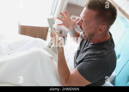Middle aged man scream on someone over phone, man not satisfied with hotel service Stock Photo