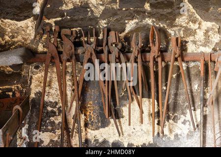 Old forging tools hanging on a wall Stock Photo
