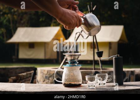Drip coffee man pouring hot water on coffee ground with filter. Stock Photo