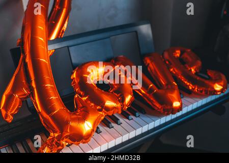 balloon in shape of word love on piano keys. copy space. Greeting card. Decoration card for event party. Cozy vibe. Celebrating Valentine's Day, anniv