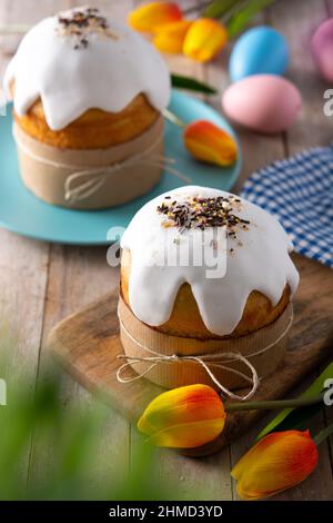 Traditional Easter cake, colorful eggs and tulips on wooden table Stock Photo
