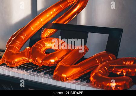 balloon in shape of word love on piano keys. copy space. Greeting card. Decoration card for event party. Cozy vibe. Celebrating Valentine's Day, anniv