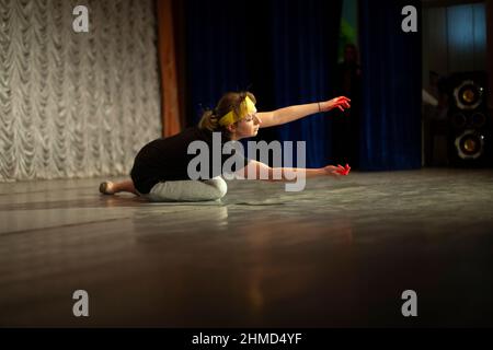 Girl shows emotions on stage. Dance teacher learns to express oneself in motion. Performance of ballerina. Stock Photo