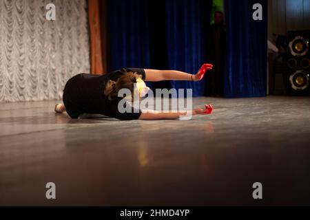 Girl shows emotions on stage. Dance teacher learns to express oneself in motion. Performance of ballerina. Stock Photo