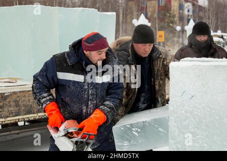 Worker with a chainsaw in hand at the assembly site Stock Photo