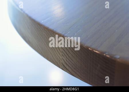 Closeup of the edge of a wooden table top in a simple plain minimalist view. Stock Photo
