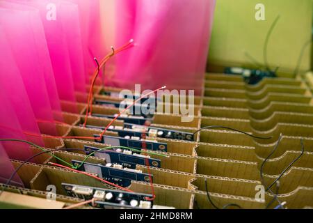 Chipset on chip board for modern TFT displays packaged in transparent pink plastic package in carton box in factory assembly workshop extreme closeup Stock Photo