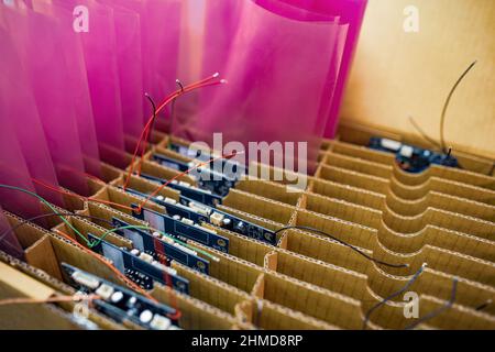 Chipset on chip board for modern TFT displays packaged in transparent pink plastic package in carton box in factory assembly workshop extreme closeup Stock Photo