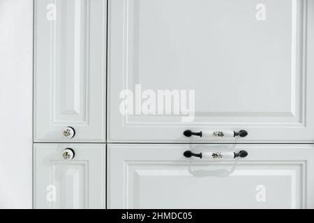 Close up detail of vintage white cabinet, original ceramic handles, selective focus, copy space Stock Photo