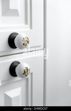 Extremely close up detail of vintage white cabinet, original ceramic handles, selective focus, copy space Stock Photo