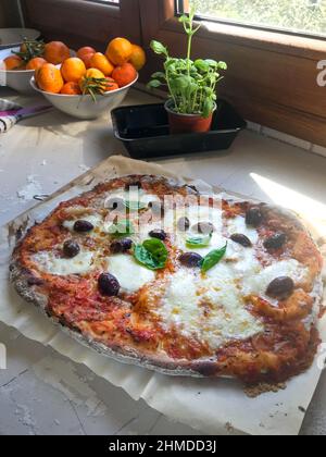 Freshly homemade pizza served in plate on window sill at home Stock Photo