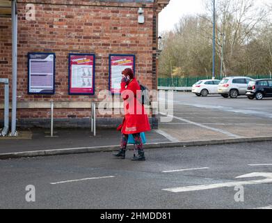 Melton Mowbray,Leicestershire,UK,9th February 2022,A lady talks on her mobile phone outside Melton Mowbray Railway Station on a grey and cloudy day.Credit: Keith Larby/Alamy Live News Stock Photo