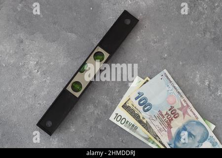 The balance of the Turkish lira against the dollar and the euro with a spirit level. Concept of imbalance in exchange rate increase. Stock Photo