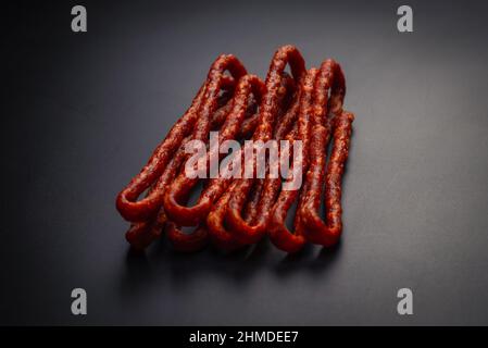 Cabanossi, dry sausage isolated on a black background. Stock Photo