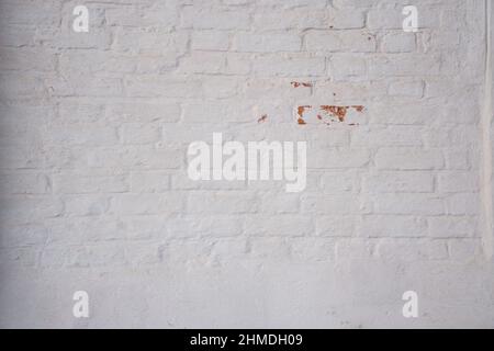 Stories of the old church. White painted church brick wall with damaged paint. Background image Stock Photo
