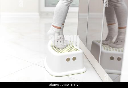 Small feet stand on a stand for children Stock Photo