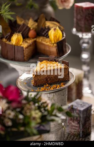Slice of layered chocolate mousse cake with caramelized nut on top, still life Stock Photo