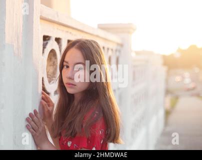 Portrait of a sad teenager girl is dreaming  outdoors at summer evening Stock Photo