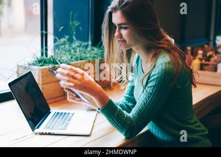Focused attractive woman watching video on contemporary tablet in cafe Stock Photo