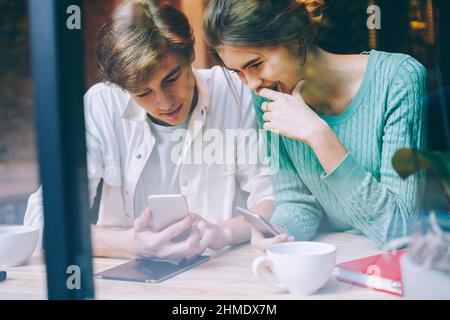 Positive friends using smartphones in cafe Stock Photo