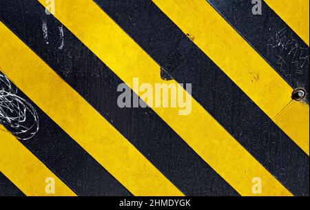 Metallic surface painted with black and yellow stripes Stock Photo