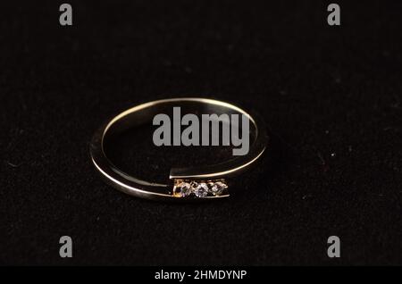 Women's ring Golden with diamonds on a black velvet background. Stock Photo