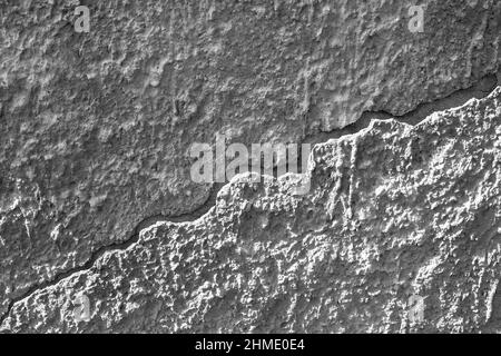 Big diagonal crack on old plastered wall. Plaster has peeled off the wall. Close up. Copy space. Selective focus. Stock Photo