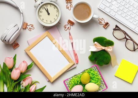 Desktop. Notepad keyboard coffee cup alarm clock on table with easter decorations. Photo frame with copy space Stock Photo