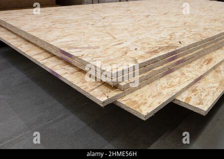 OSB pressed wood sheets stacked in store. Construction materials Stock Photo