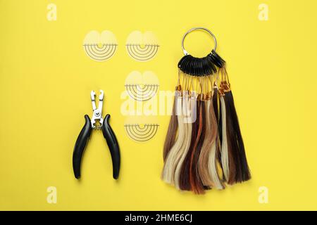 Composition with hair extension accessories on yellow background Stock Photo